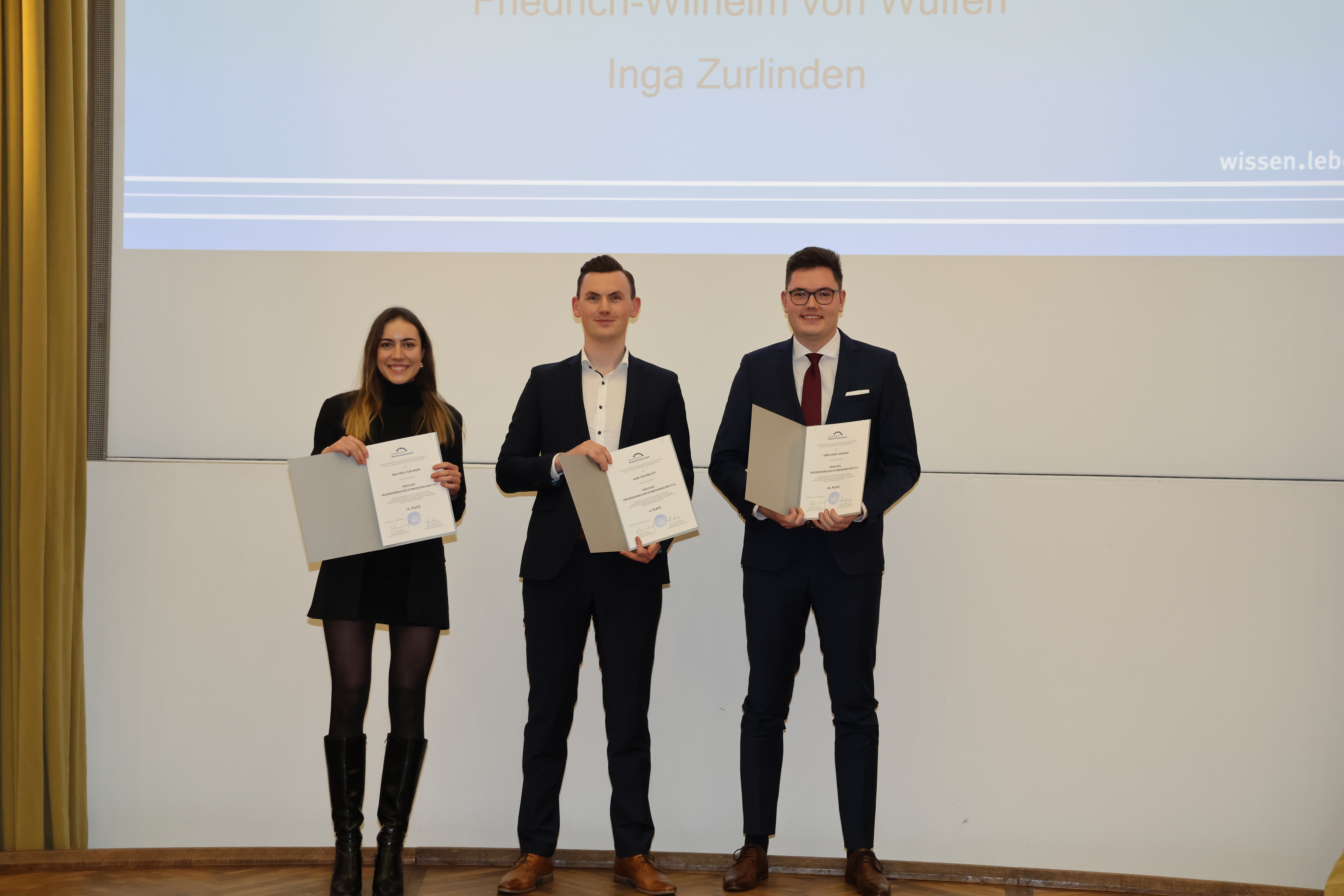 Drei der Examensbesten bei der Examensfeier im Wintersemester 2024/2025.